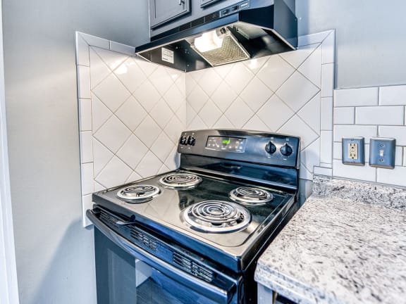 a kitchen with a stove and a microwave at Ashford Place Apartments, Kannapolis, NC 28081