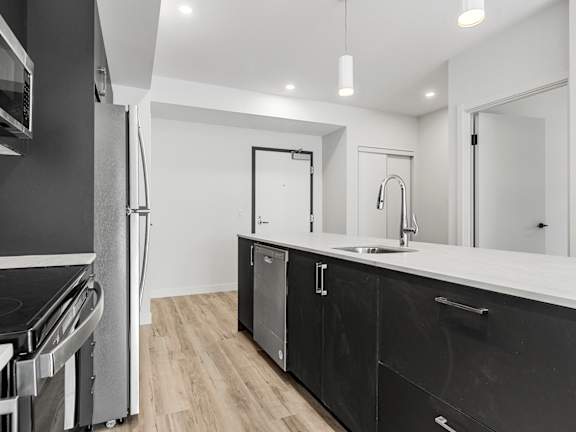 A modern kitchen with white cabinets and a stainless steel refrigerator.