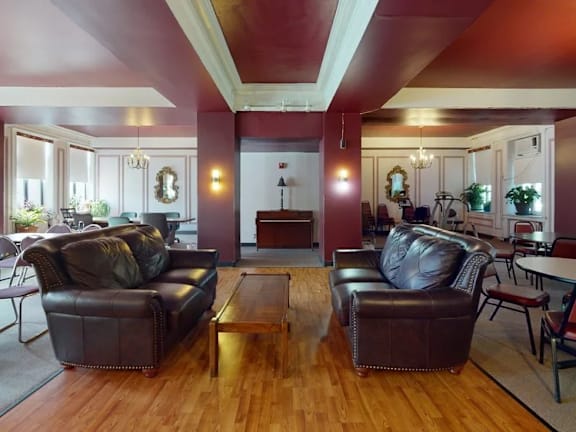 A living room with brown leather couches and a wooden floor.