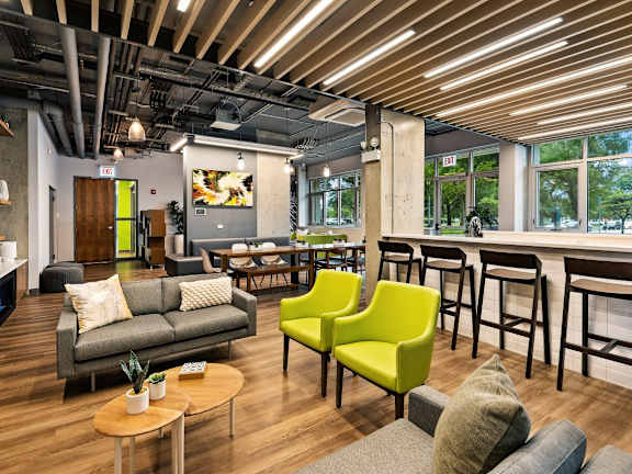 A modern living room with a grey couch, yellow chairs and a wooden coffee table.