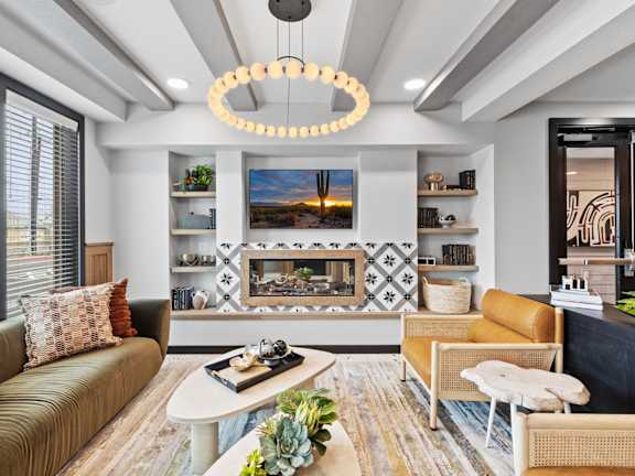 A modern living room with a fireplace and a large painting above it.
