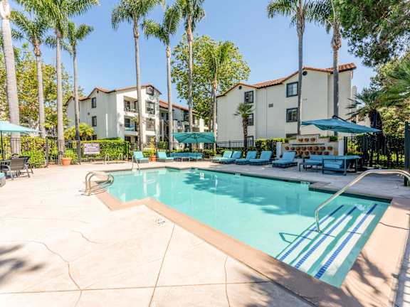 our apartments have a swimming pool with chairs and umbrellas