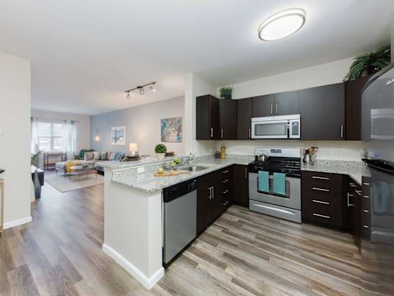 A kitchen with a white island and black cabinets.