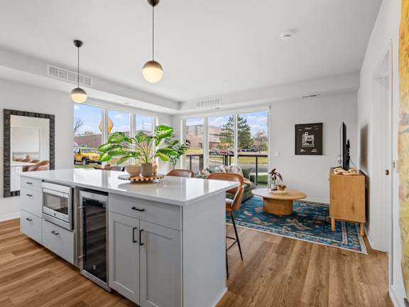A kitchen with wooden floors and a large island with a plant on it.