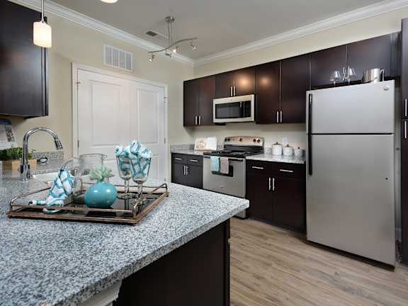 A kitchen with a granite countertop and stainless steel appliances.
