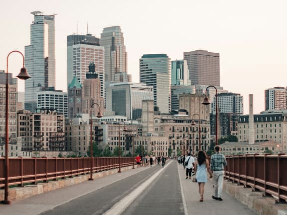 people walking on a bridge over the city