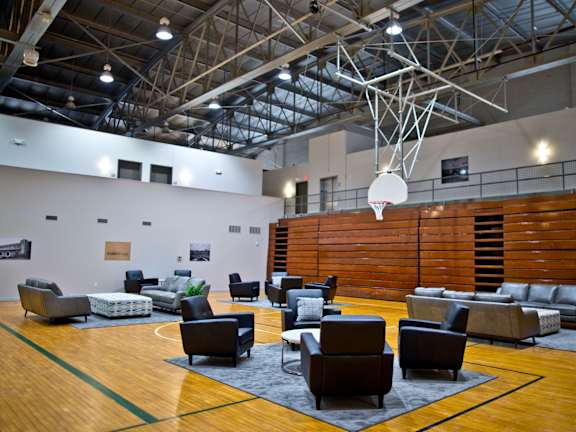 A basketball court with a hoop and a variety of seating.