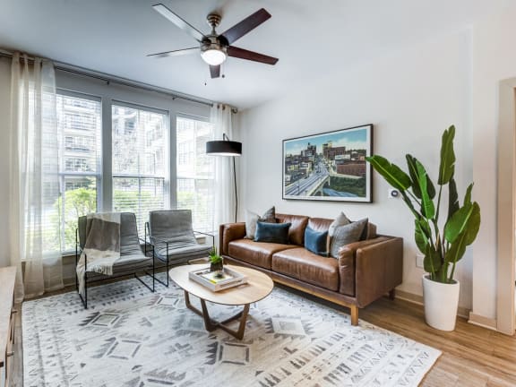a living room with a couch and a chair and a ceiling fan