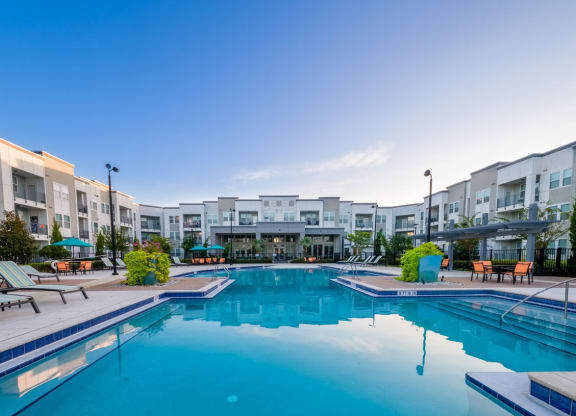 a swimming pool with an apartment building in the background at Linden on the GreeneWay, Florida