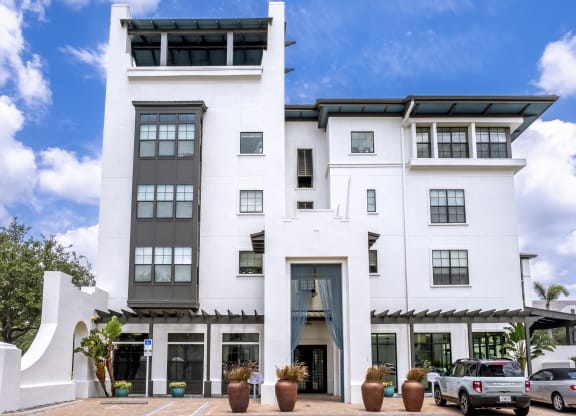 a large white building with cars parked in front of it at Azul Baldwin Park, Florida