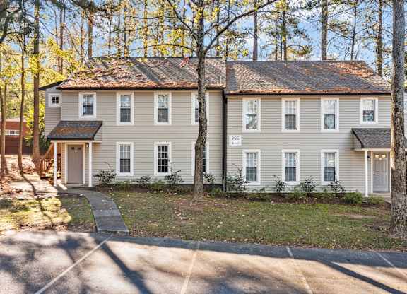 A two-story house with a grey exterior and a brown roof at West Oak Apartments, Wake Forest, NC