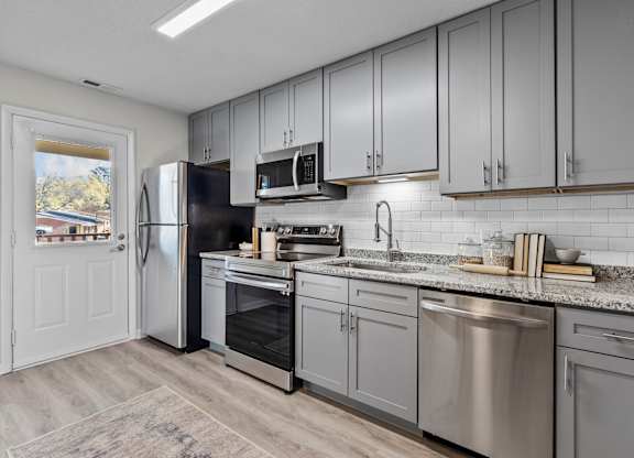 A kitchen with a refrigerator, oven, and microwave at West Oak Apartments, North Carolina 27587