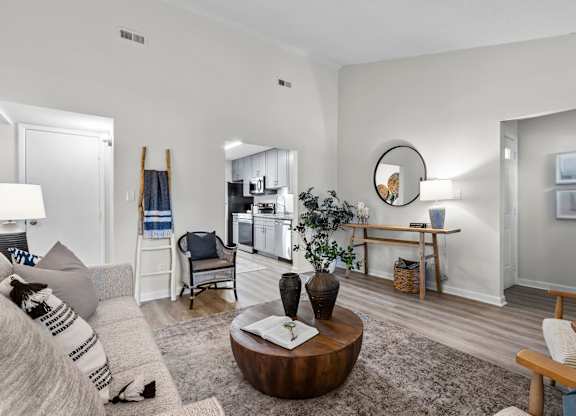 A living room with a grey couch and a wooden coffee table at West Oak Apartments, North Carolina 27587