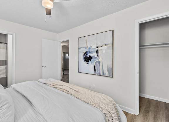 A bedroom with a large bed and a painting on the wall at West Oak Apartments, Wake Forest, NC 27587