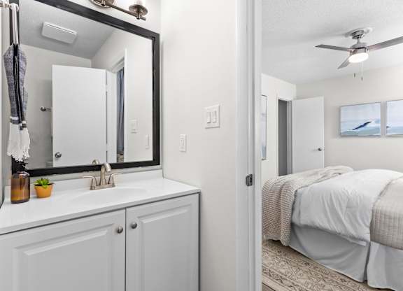 A bathroom with a white sink and a large mirror at West Oak Apartments, North Carolina