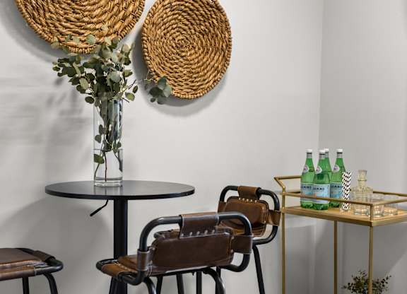 A table with a vase of flowers and two bottles of water on it at West Oak Apartments, Wake Forest, North Carolina