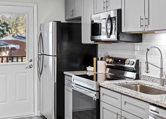 A kitchen with a black fridge and stove at West Oak Apartments, Wake Forest, NC