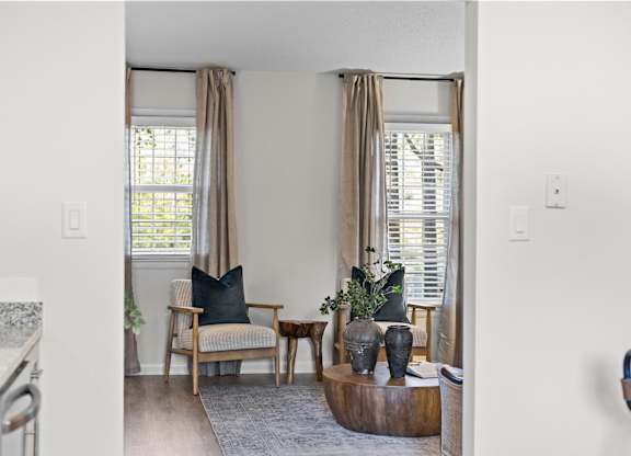 A living room with a chair, a table, and a plant at West Oak Apartments, Wake Forest, NC 27587