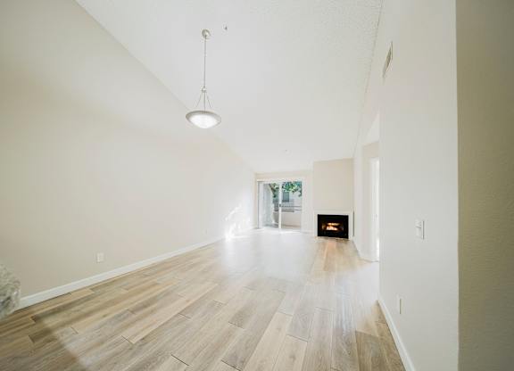 A room with wooden floors and a fireplace. at Legends at Rancho Belago, Moreno Valley, CA