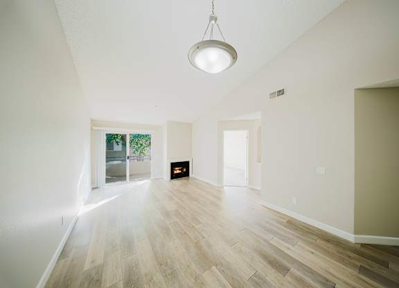 A room with a light hanging from the ceiling and a fireplace in the middle. at Legends at Rancho Belago, Moreno Valley