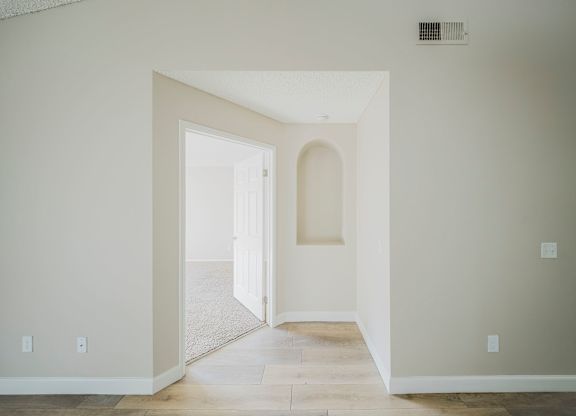 A white hallway with a doorway leading to another room. at Legends at Rancho Belago, Moreno Valley, CA, 92553