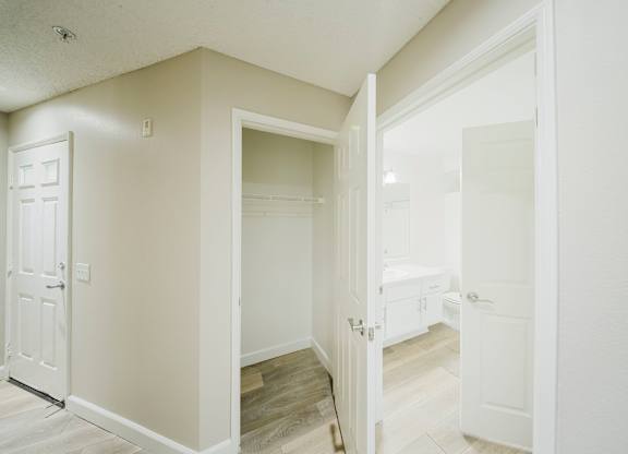 A white door is open to a room with a wooden floor. at Legends at Rancho Belago, Moreno Valley