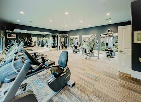 A gym with treadmills, elliptical machines, and other exercise equipment. at Legends at Rancho Belago, Moreno Valley