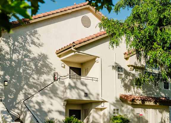 A white building with a red tile roof and a balcony. at Legends at Rancho Belago, Moreno Valley, 92553