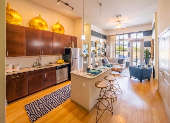 a living room with a kitchen and a bar with stools at Azul Baldwin Park, Orlando, Florida
