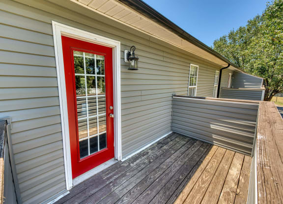 a red door on a house with a deck at Ashford Place Apartments, Kannapolis, 28081
