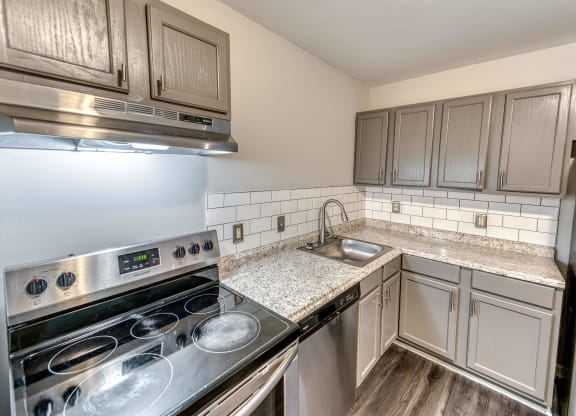a kitchen with stainless steel appliances and granite counter tops at Ashford Place Apartments, Kannapolis North Carolina