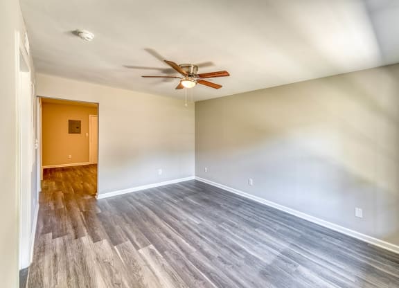 an empty living room with a ceiling fan and wood floors at Ashford Place Apartments, Kannapolis, 28081
