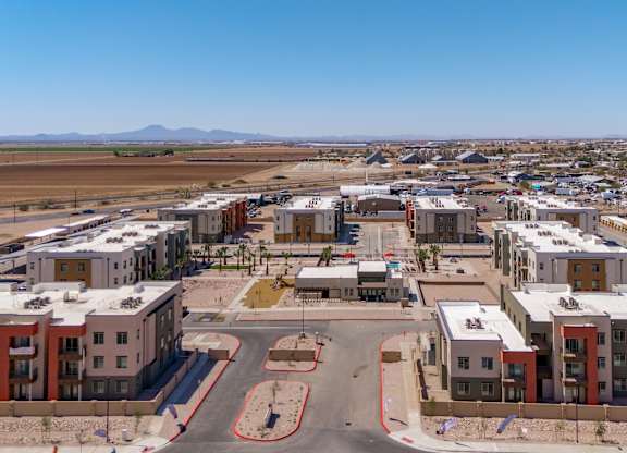 A large, modern housing complex with a central courtyard and a road running through it.