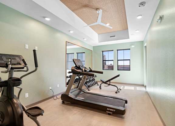 A spacious home gym with a treadmill, elliptical trainer, and stationary bike.