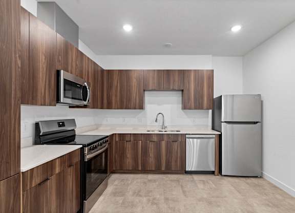 A modern kitchen with wooden cabinets and stainless steel appliances.