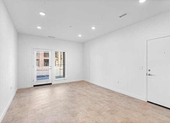 A large empty room with a door on the right side.