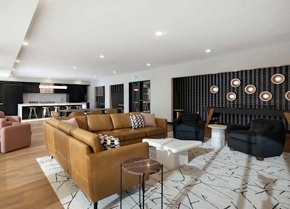 A modern living room with a large sectional sofa and a patterned rug.