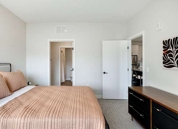 A bedroom with a large bed and a dresser.