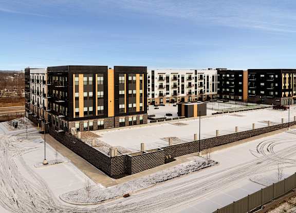 A row of modern buildings with a snowy landscape in the foreground.