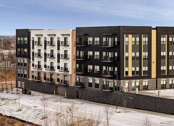 A row of modern apartment buildings with balconies and windows.