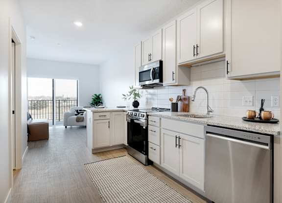A modern kitchen with stainless steel appliances and white cabinets.