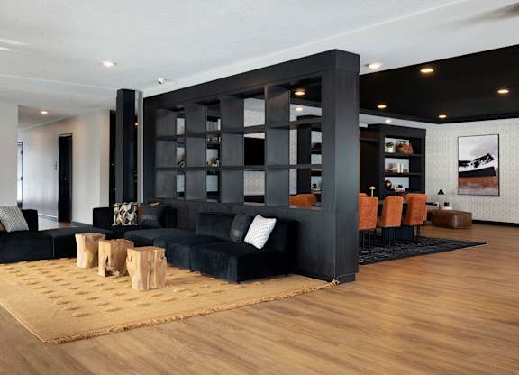 A black and wood living room with a large black bookshelf.