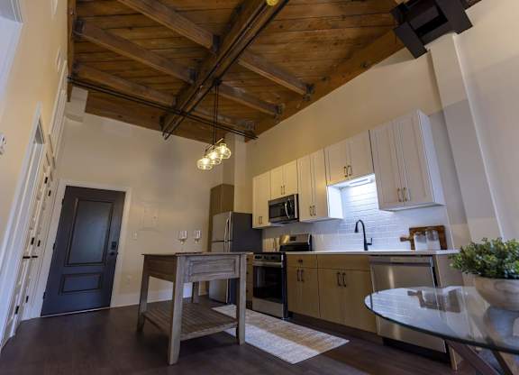 A kitchen with wooden cabinets and a black door. at The Dean at Creekview Apartments, Newark, DE