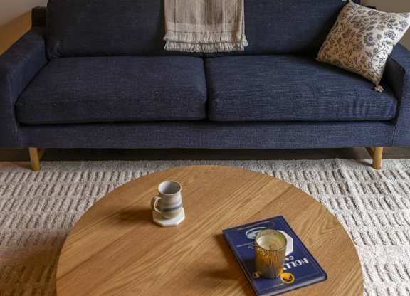 A blue couch with a wooden table in front of it at The Dean at Creekview Apartments, Newark, 19711