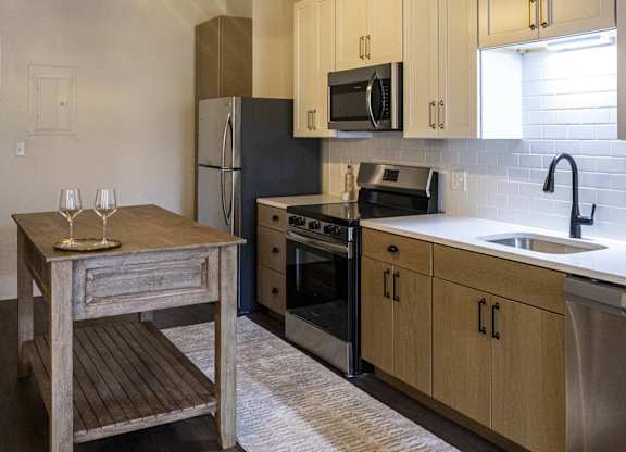 A kitchen with a black fridge and wooden cabinets at The Dean at Creekview Apartments, Delaware, 19711
