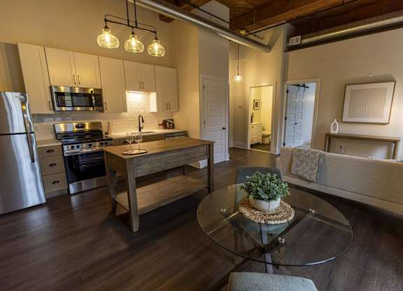A modern kitchen with a glass table and a plant on it at The Dean at Creekview Apartments, Delaware