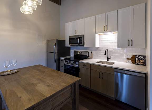 A kitchen with a wooden table and stainless steel appliances at The Dean at Creekview Apartments, Delaware