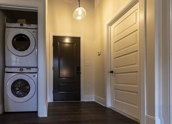 A laundry room with a washer and dryer stacked on top of each other at The Dean at Creekview Apartments, Newark