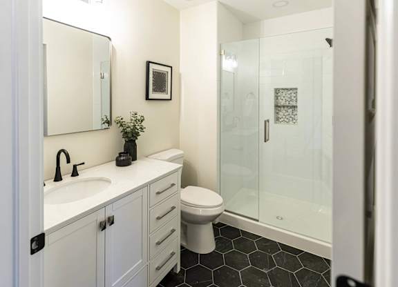 A bathroom with a sink, toilet, and shower at The Dean at Creekview Apartments, Delaware, 19711