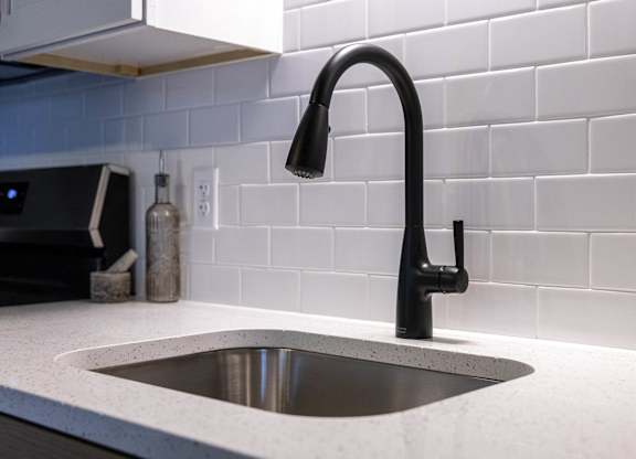 A modern kitchen sink with a black faucet at The Dean at Creekview Apartments, Newark, 19711